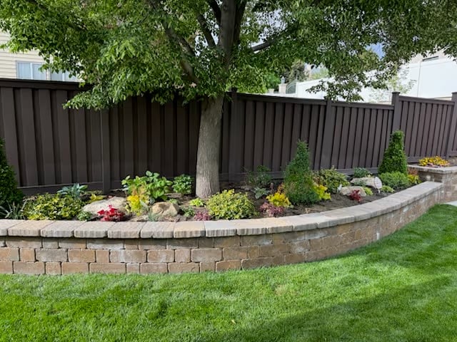 Finished Utah backyard with sod, retaining wall, and fence by Alpine Fence & Deck